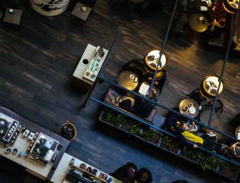 Aerial view of a cosy café interior with people sitting at tables, drinking coffee under warm hanging lights