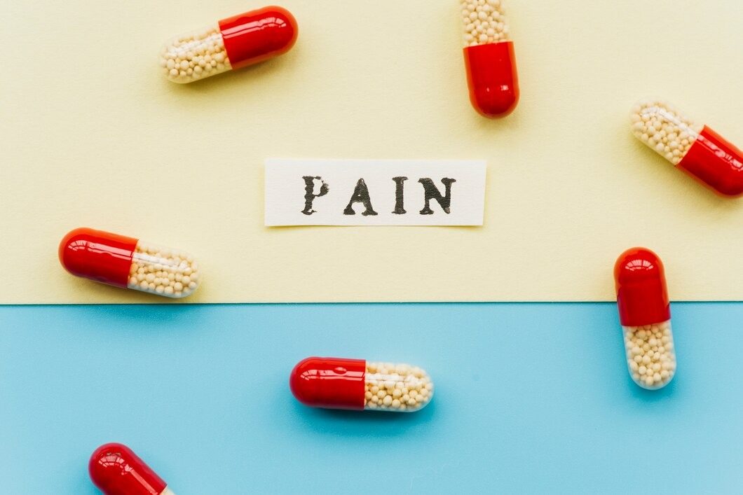 Pain pills scattered on a vibrant blue and yellow background, highlighting their colors and shapes